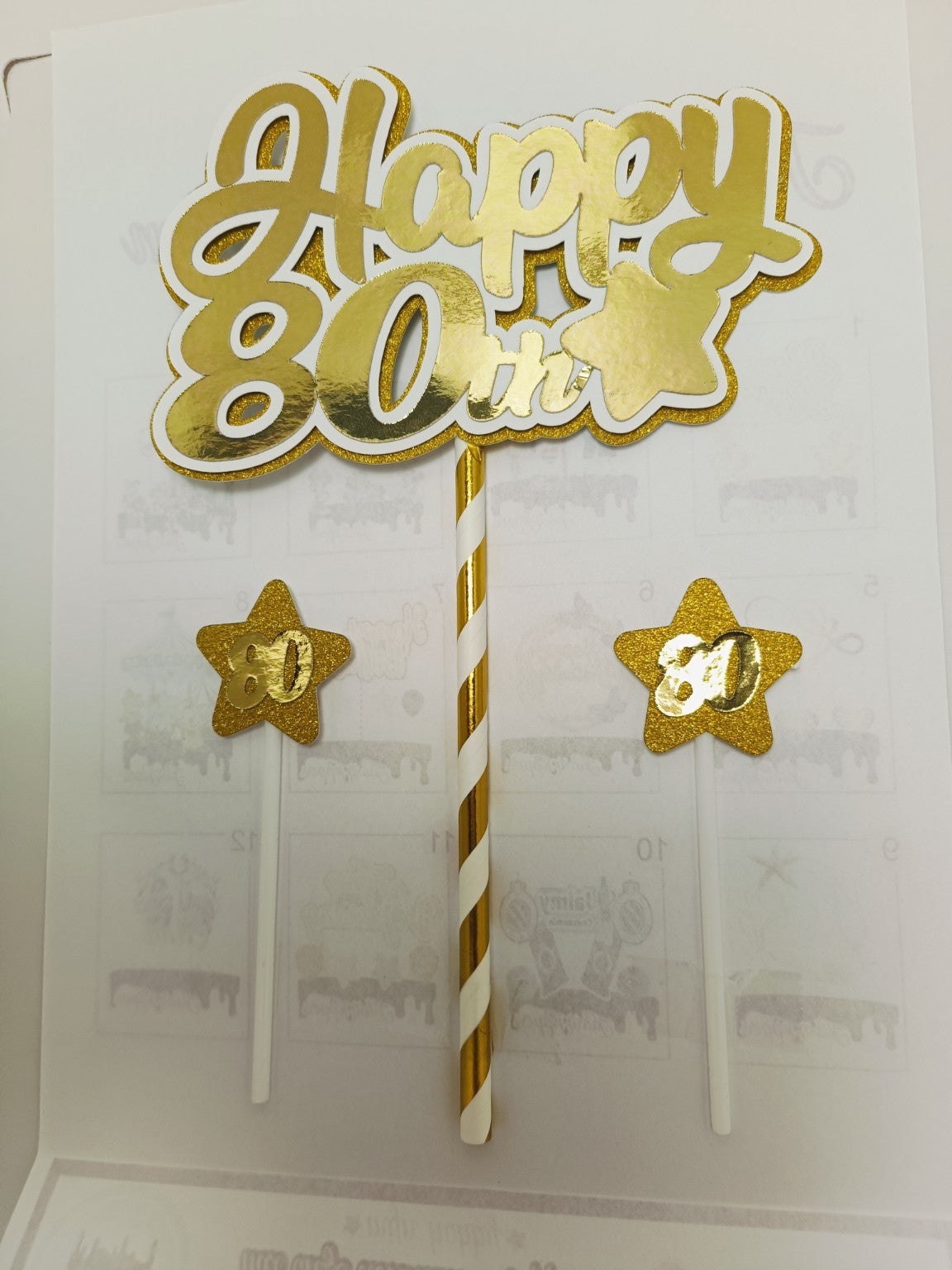 Gouden Happy leeftijdstaarttopper met twee kleine sterren, voorbeeld 80 jaar